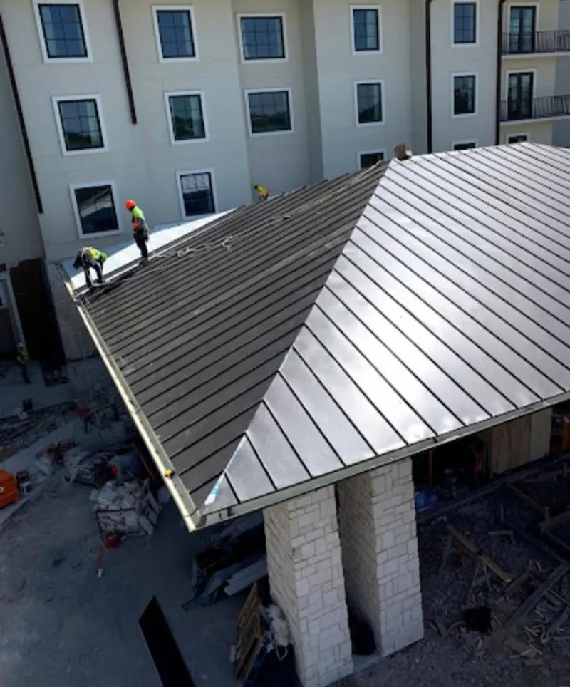 Crew installing standing seam metal roof panels on a commercial project in Shoreline